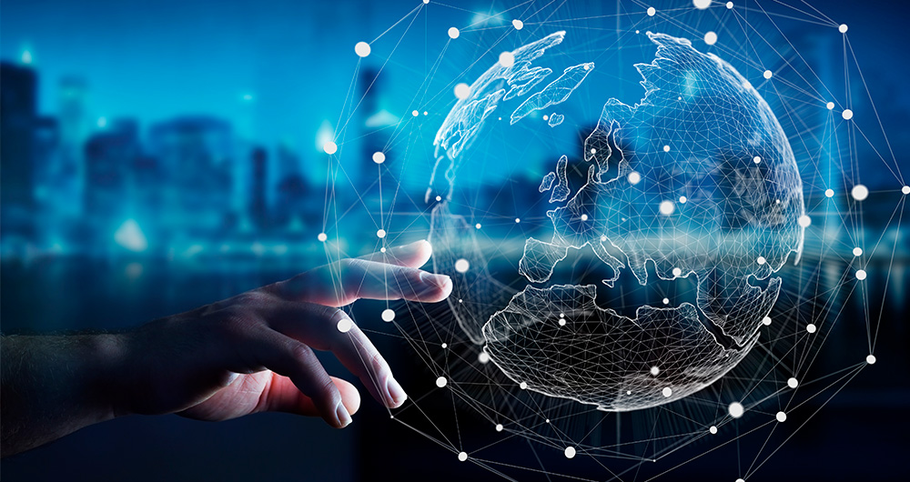 Una mano toca una proyección holográfica del mundo, sobre el fondo de una ciudad de noche