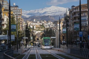 El metro de Granada con la Sierra Nevada al fondo, a su paso por Caleta.
