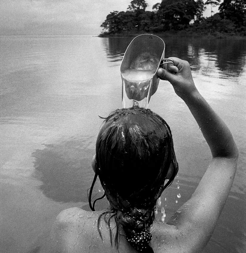 Mujer de espaldas en el mar echándose agua en la cabeza (fotografía de Rafael Trobat)