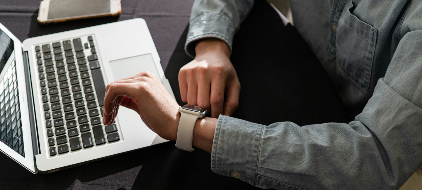 Señor delante de ordenador mirando reloj