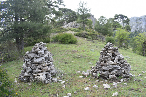 Dos hitos de piedra en un sendero de montaña, usados para señalización y orientación.